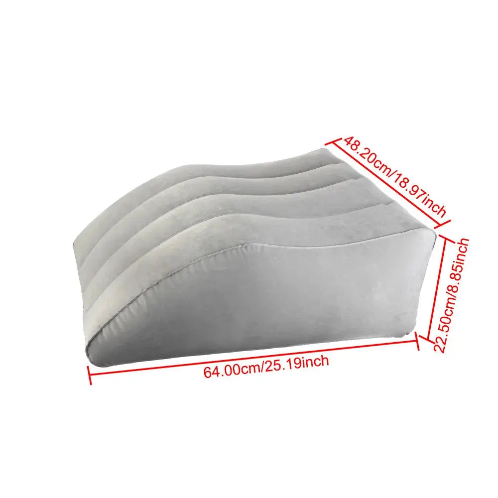Close-up of a hand pressing on a partially inflated leg elevation pillow, demonstrating adjustable firmness