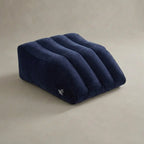 Hand compressing the surface of an inflatable wedge pillow to show how it can provide soft, gentle support